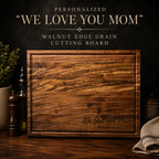 Personalized walnut cutting board engraved with We Love You Mom message
